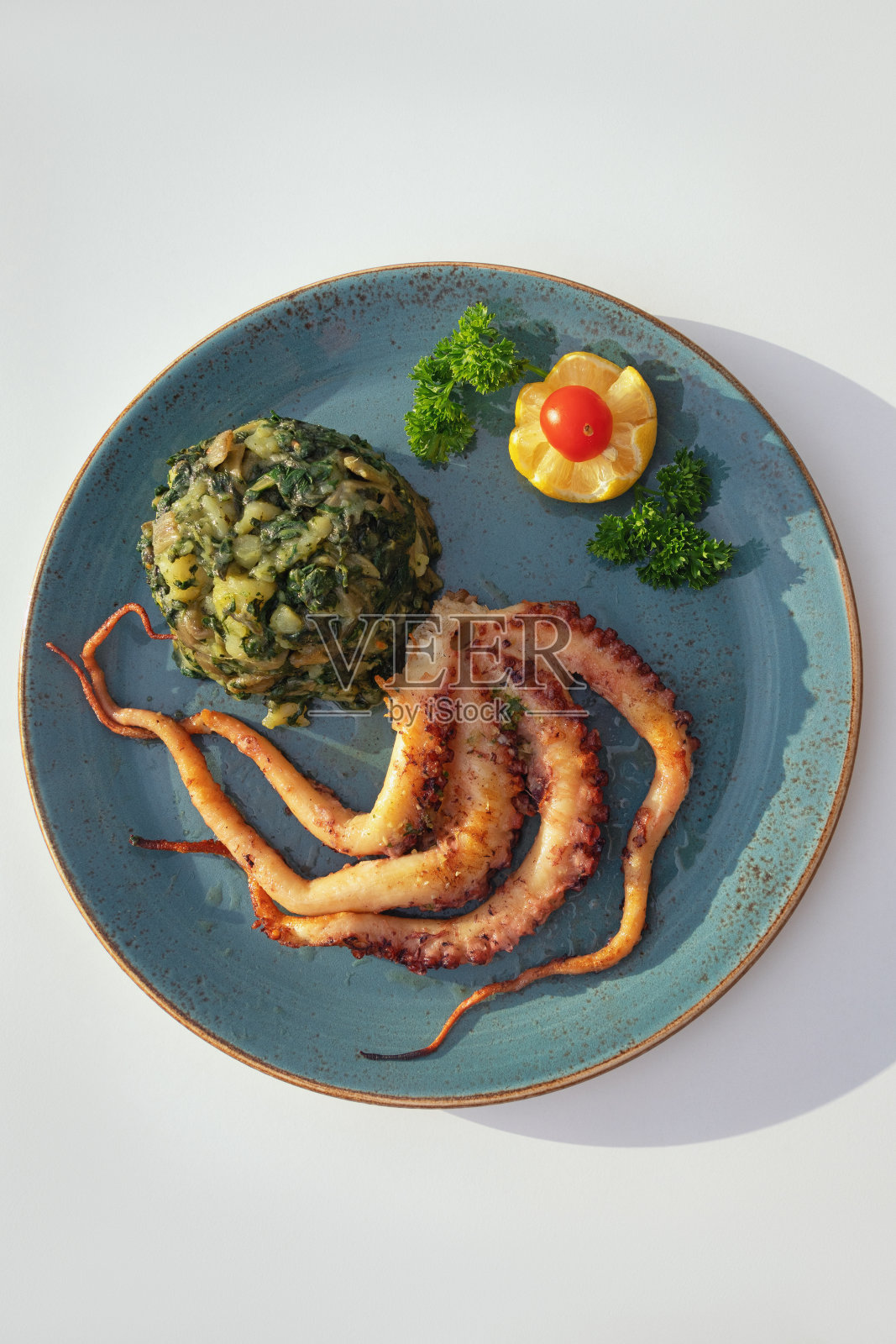 配烤章鱼和绿叶蔬菜照片摄影图片