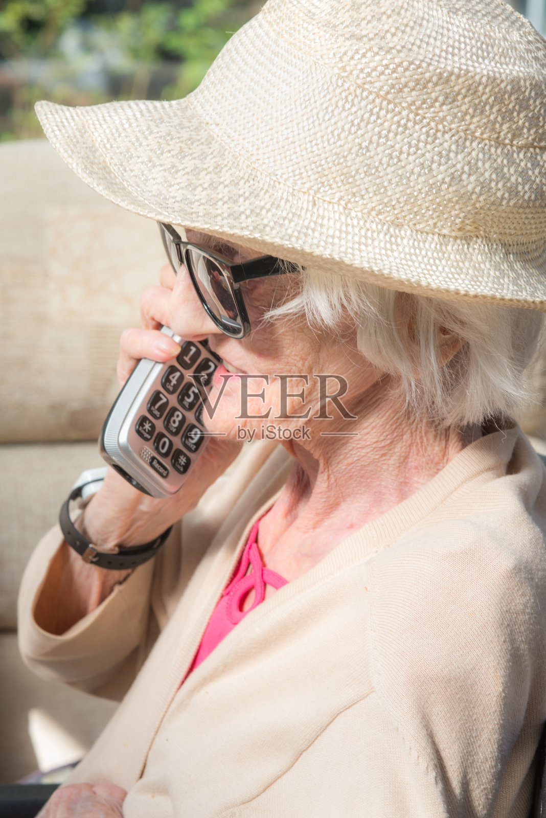 英国，在夏天，一位老妇人在外面打电话。照片摄影图片