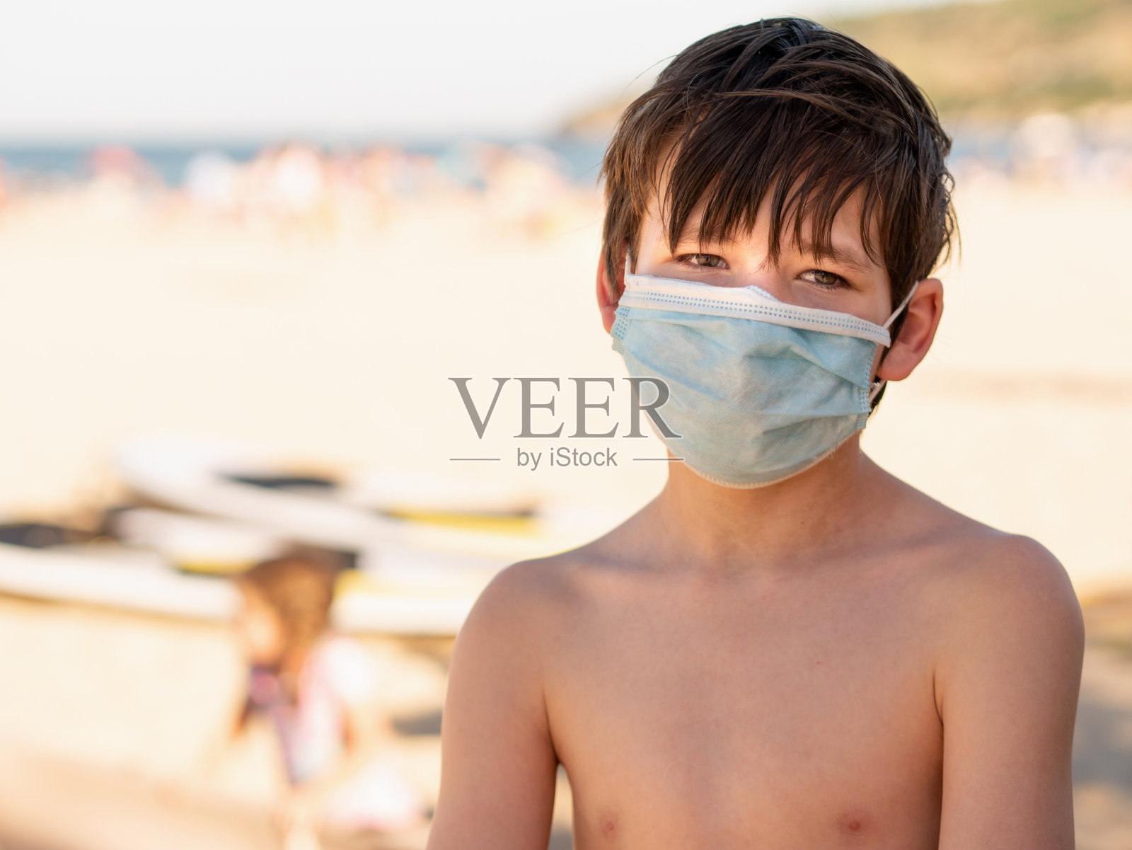 带着医用口罩在海滩上照片摄影图片