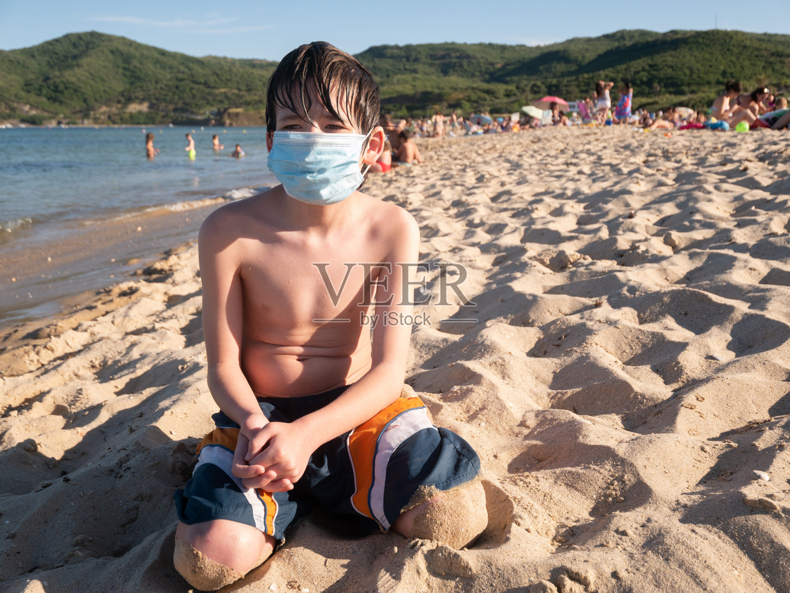带着医用口罩在海滩上照片摄影图片