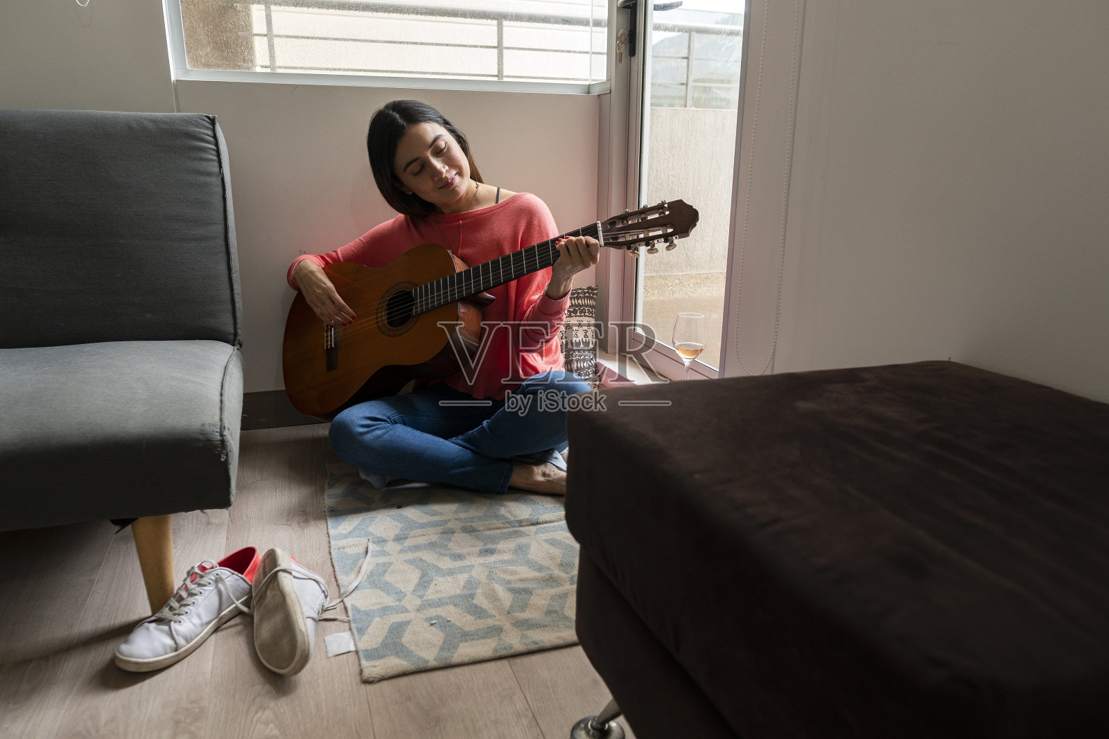 一个女人喜欢从家里的窗户弹吉他照片摄影图片