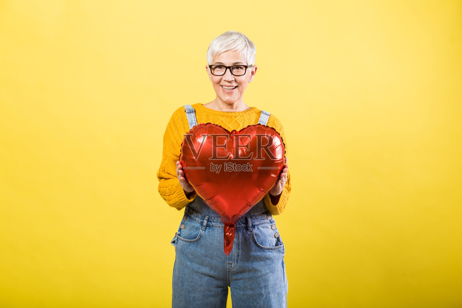 一个拿着心形气球的老妇人照片摄影图片