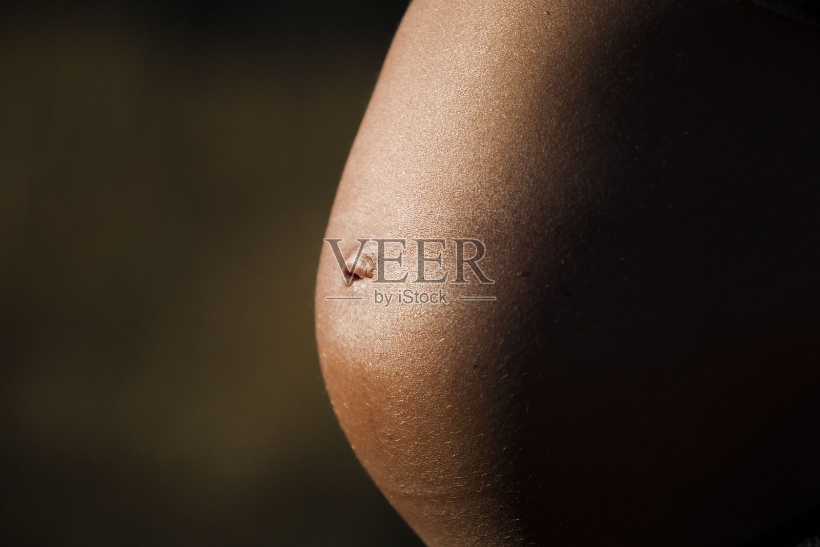 一个孕妇腹部的特写。照片摄影图片