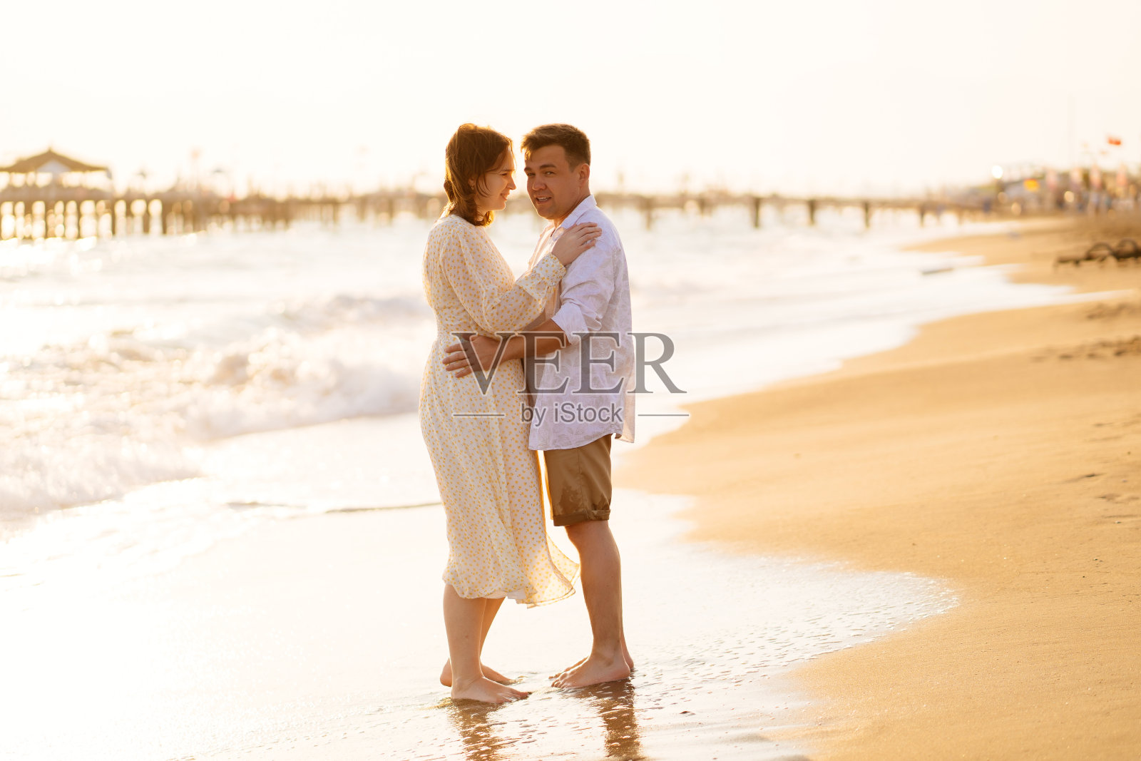 情侣站在沙滩上的海岸线上。恋爱，一起旅行。照片摄影图片