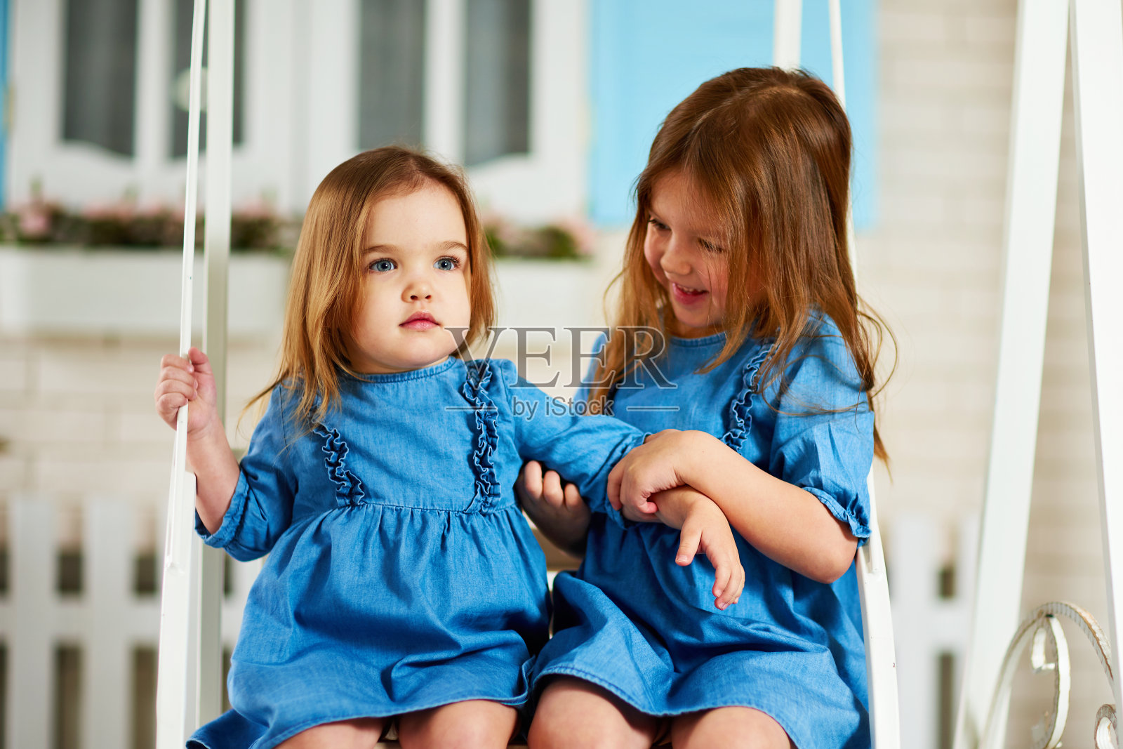 两个漂亮的小女孩姐妹在一起玩。照片摄影图片