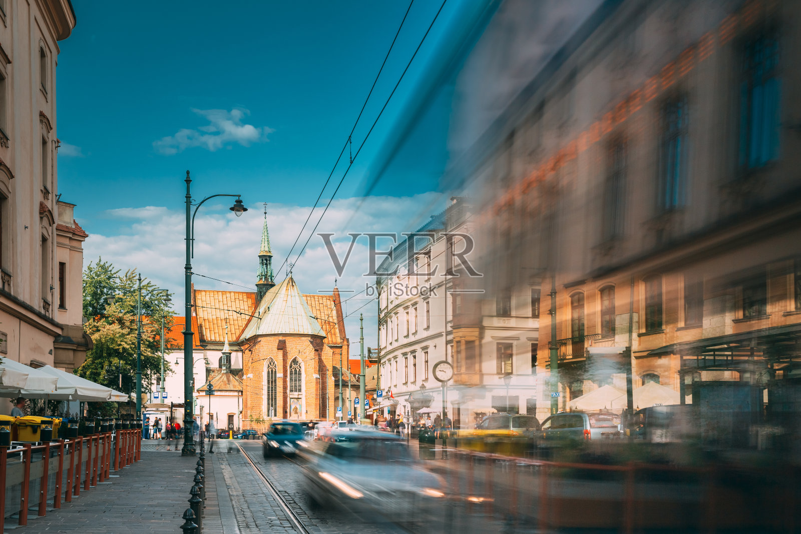 克拉科夫,波兰。多米尼加广场附近的有轨电车。交通与圣方济会修道院和阿西西的圣方济会大教堂背景照片摄影图片
