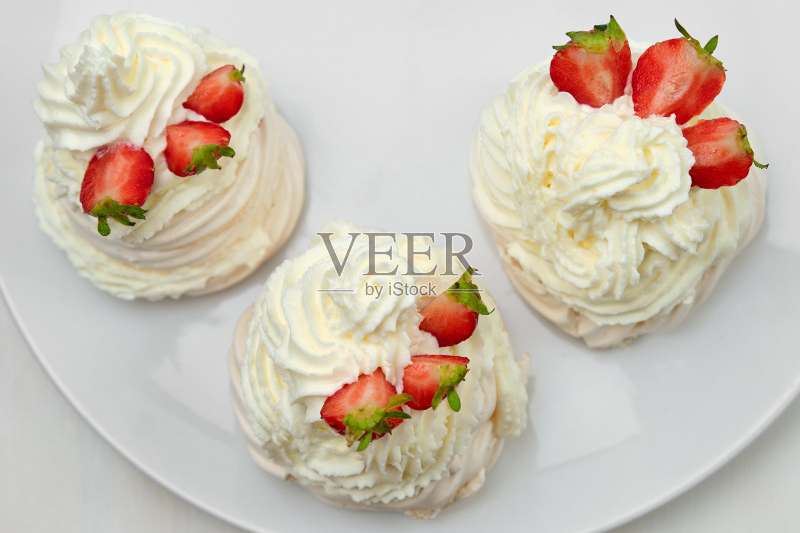 白底草莓和鲜奶油的蛋白霜。自制Anna Pavlova甜点。照片摄影图片