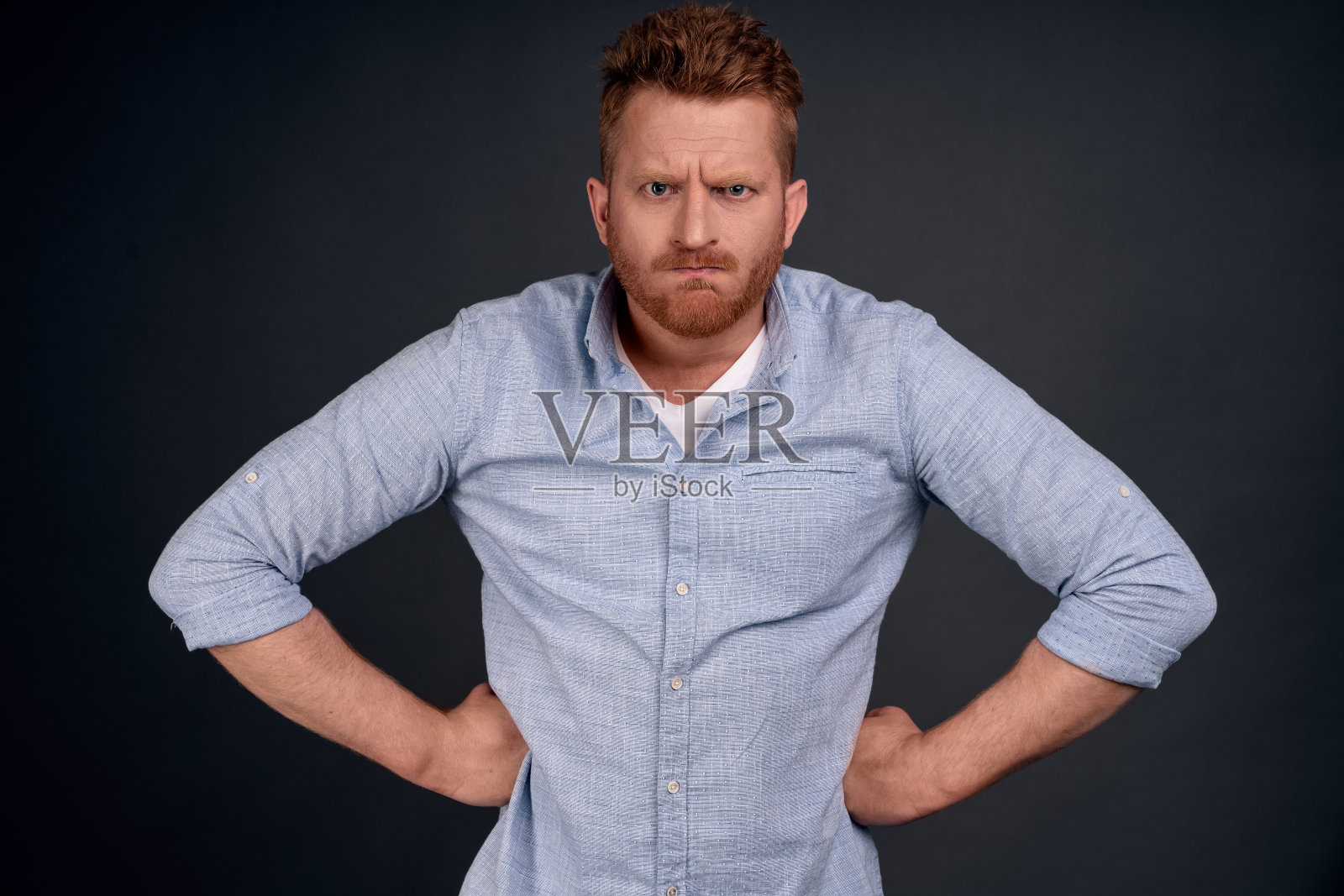 谁拿了我的手机。这位帅气的成年父亲穿着白色t恤，戴着墨镜，手牵着腰，盯着镜头，表情严肃，对着灰色的背景发着怒照片摄影图片