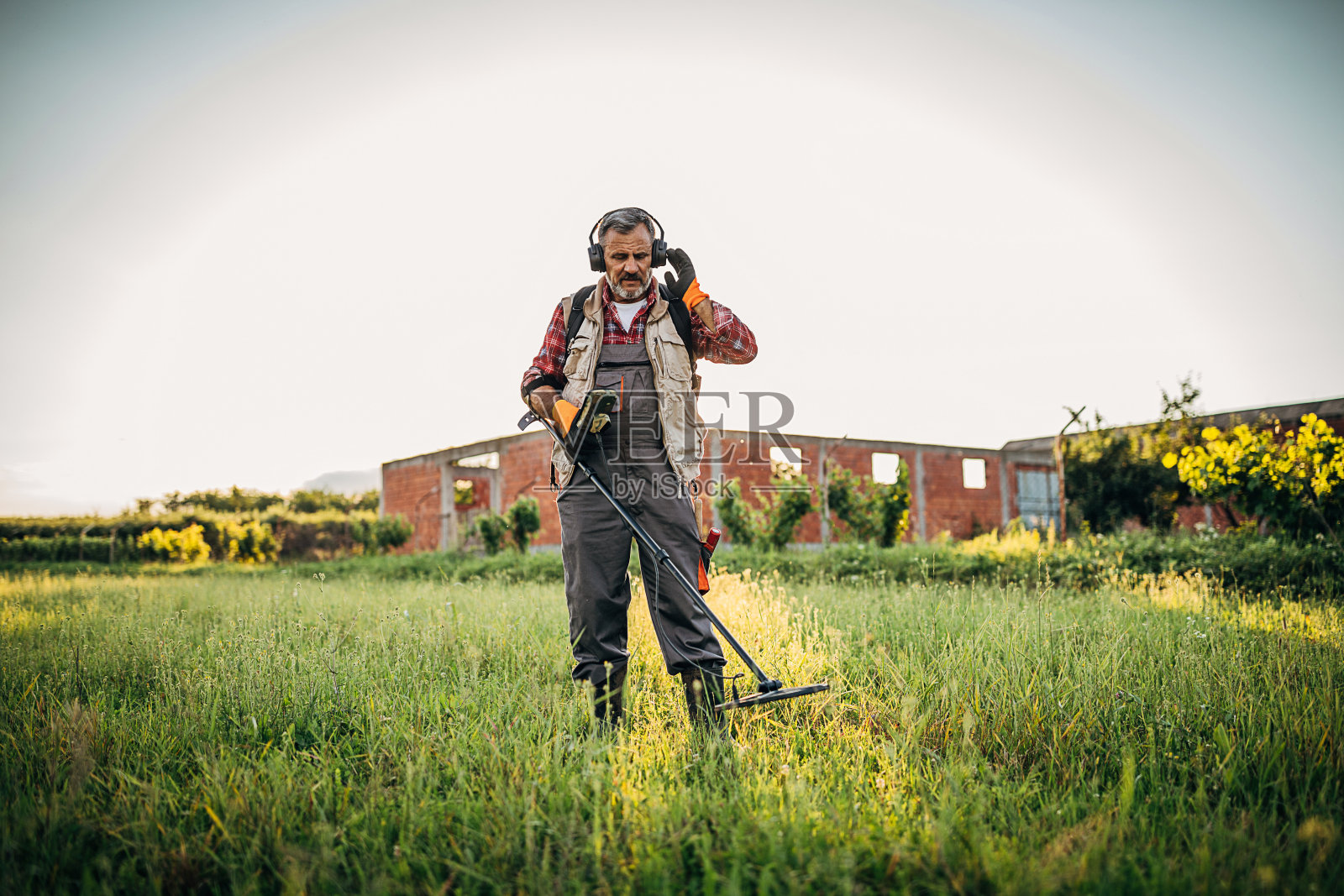 一个拿着金属探测器寻找宝藏的老人照片摄影图片