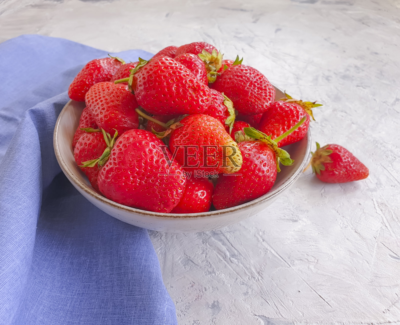 混凝土背景上的草莓板照片摄影图片