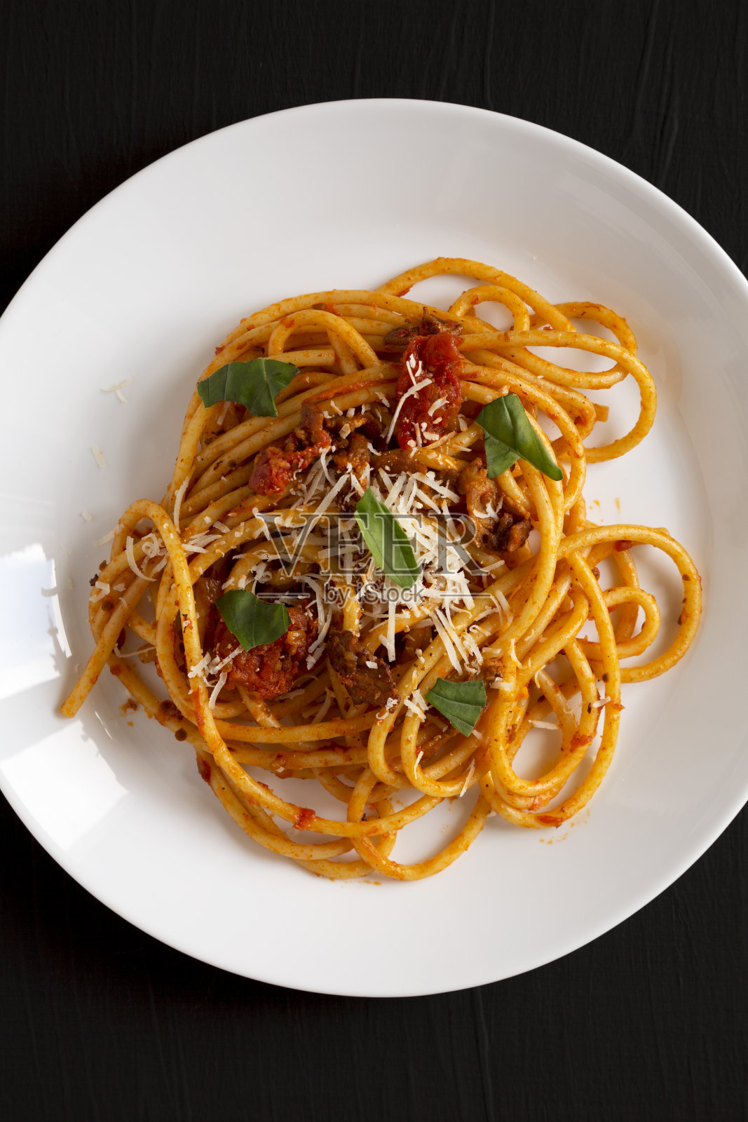 美味的自制阿马特里西酱意大利面，白色盘子，黑色背景，俯视图。平躺着，从上面俯视。照片摄影图片