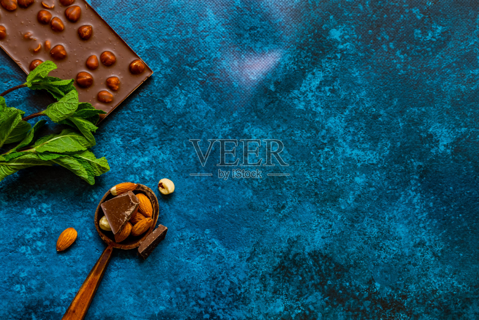 蓝色背景下的榛子巧克力块照片摄影图片