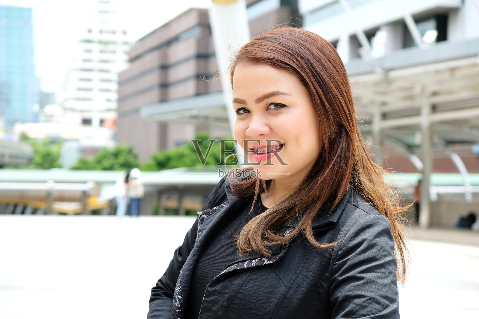 肖像美丽的年轻亚洲妇女站在办公大楼前在商业区。照片摄影图片