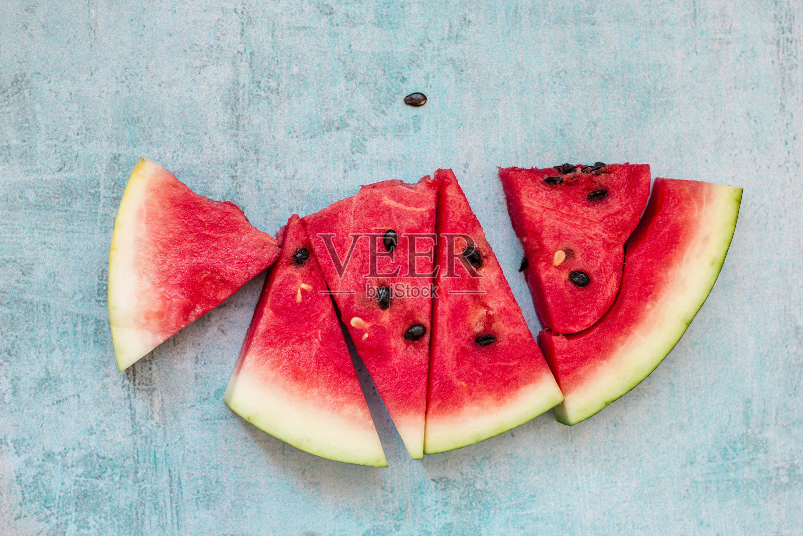 浅蓝色表面上的西瓜片照片摄影图片