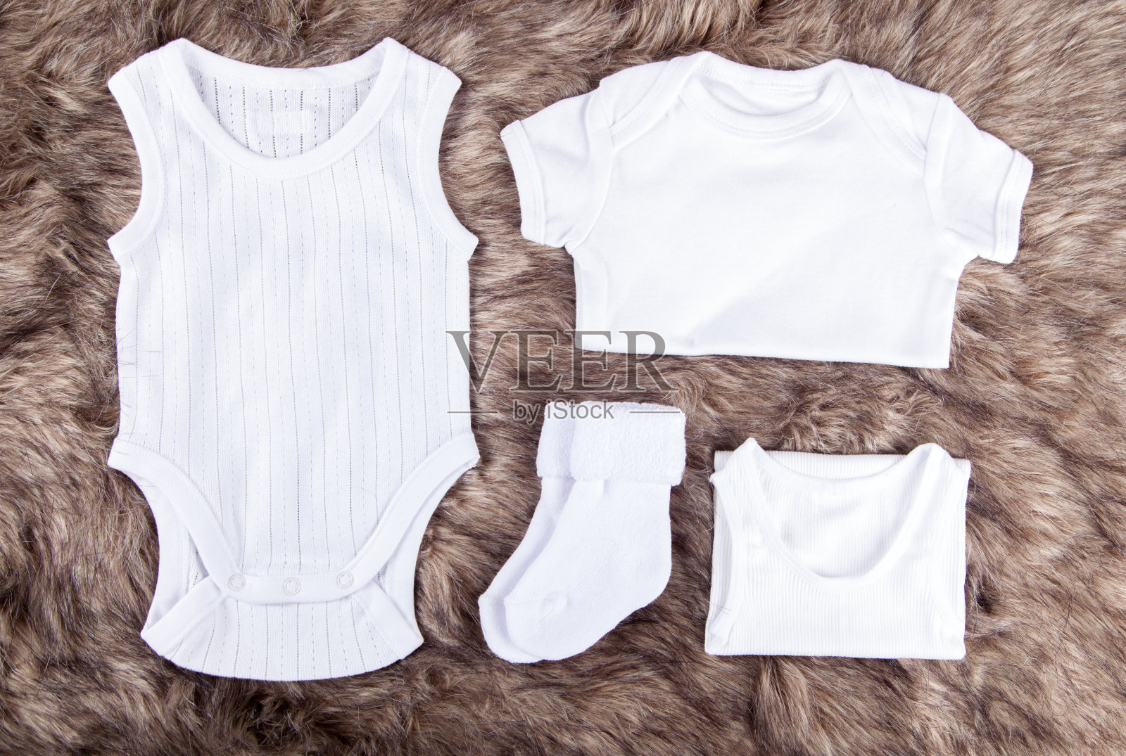 新生儿婴儿服装和柔软的毛皮背景的项目照片摄影图片