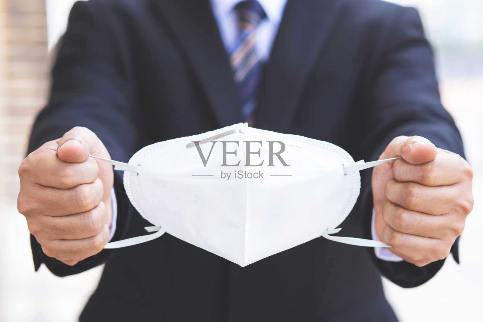 一名商人在上班前戴着口罩来保护科罗娜病毒。照片摄影图片