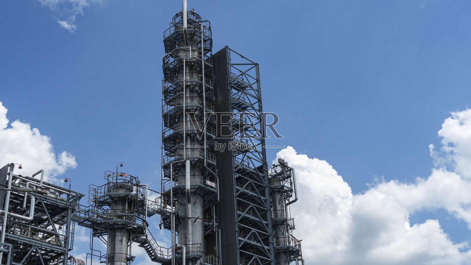 炼油厂。石化工业厂房上的经典蓝天背景。空间的文本。汽油生产观念。照片摄影图片