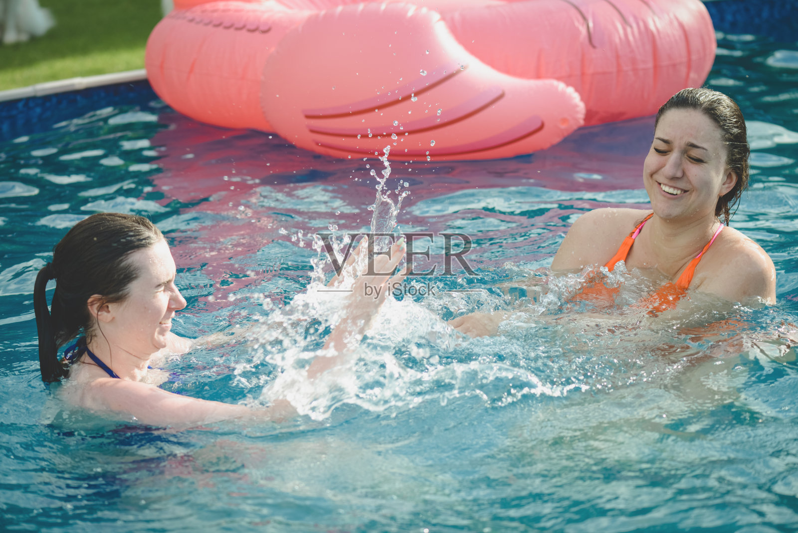 年轻漂亮的女人在泳池里游泳照片摄影图片