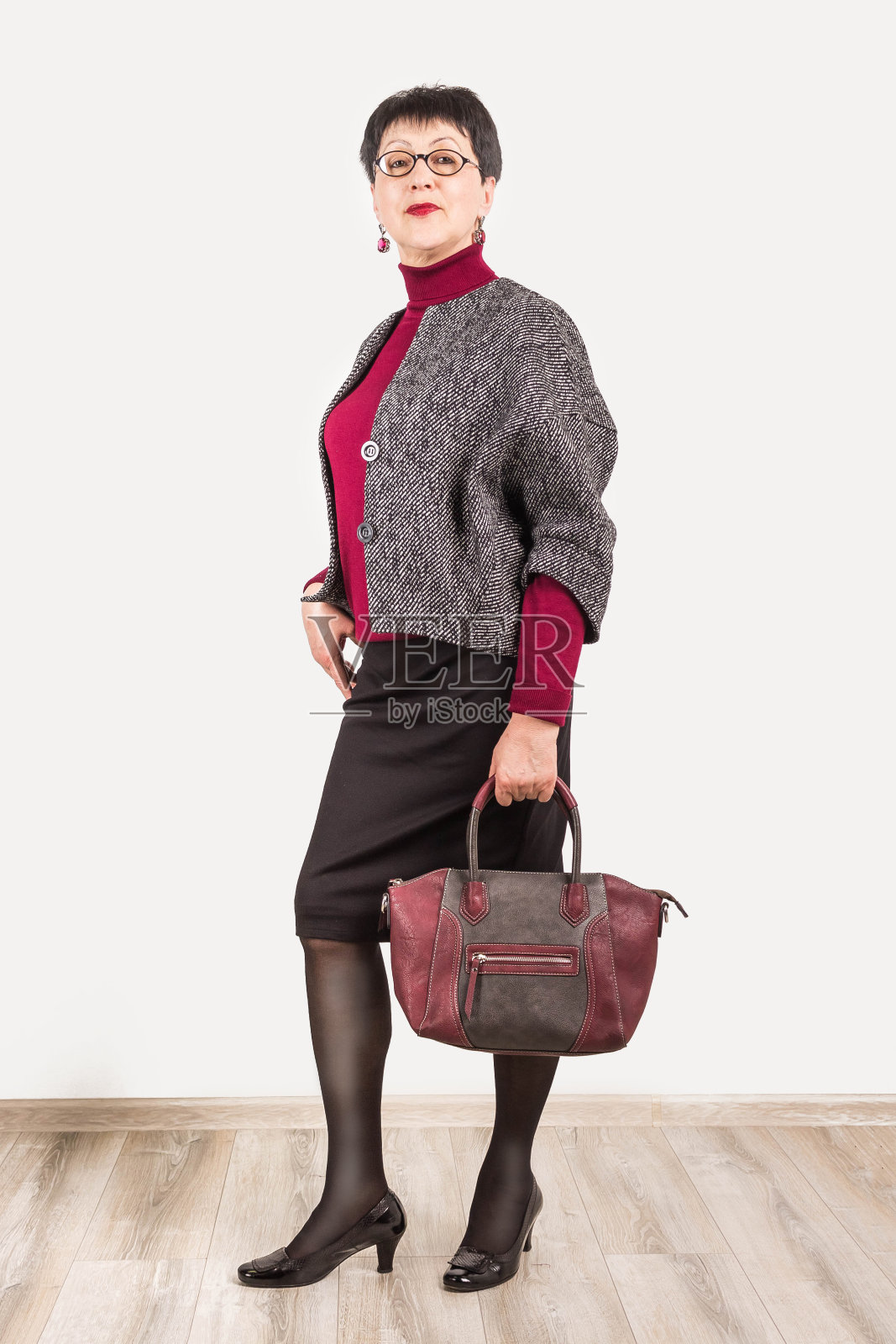 资深女商人孤立地站在灰色的工作室背景照片摄影图片
