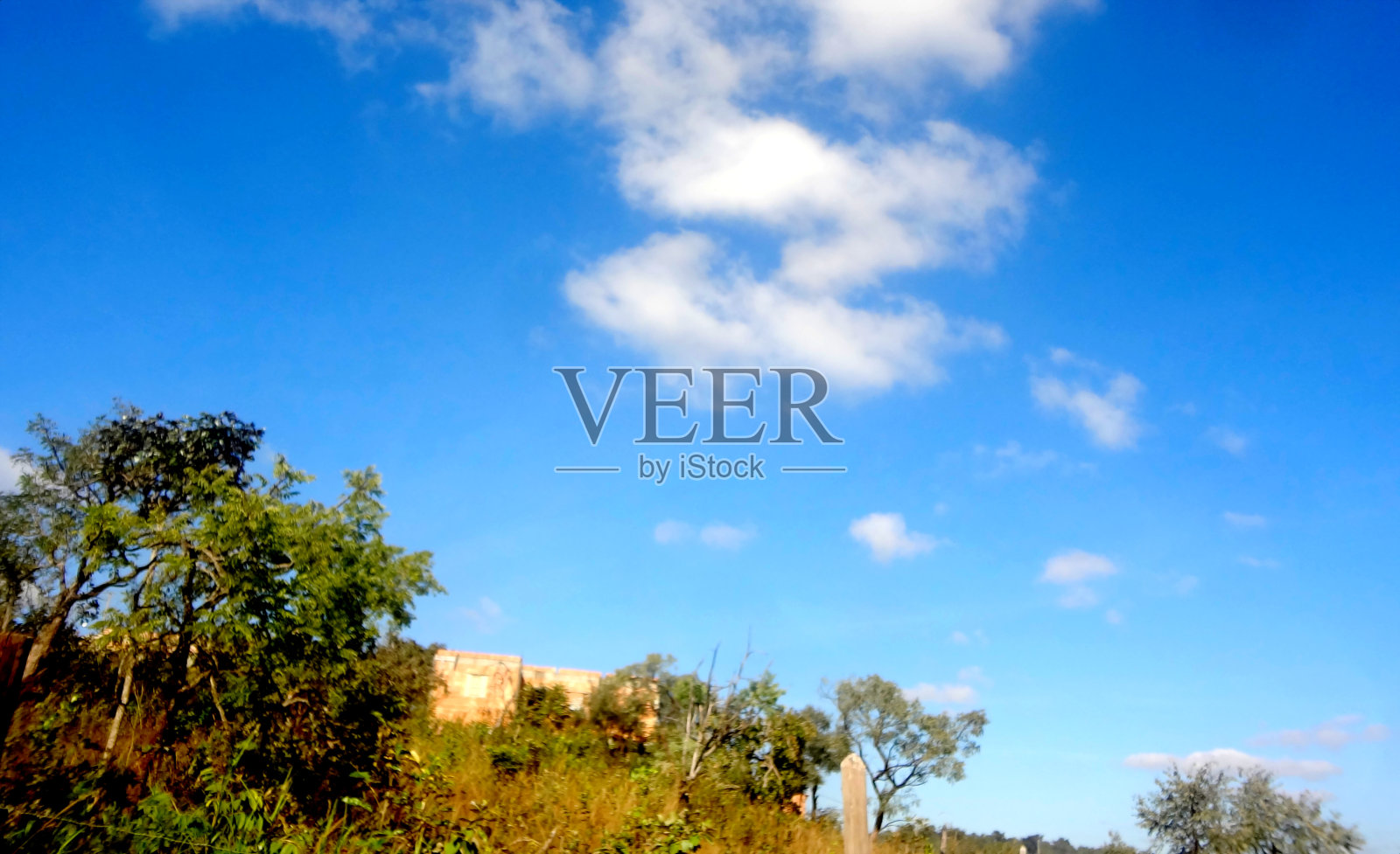 风景摄影，有树木和美丽的蓝天，旁边和上面有一座小建筑照片摄影图片