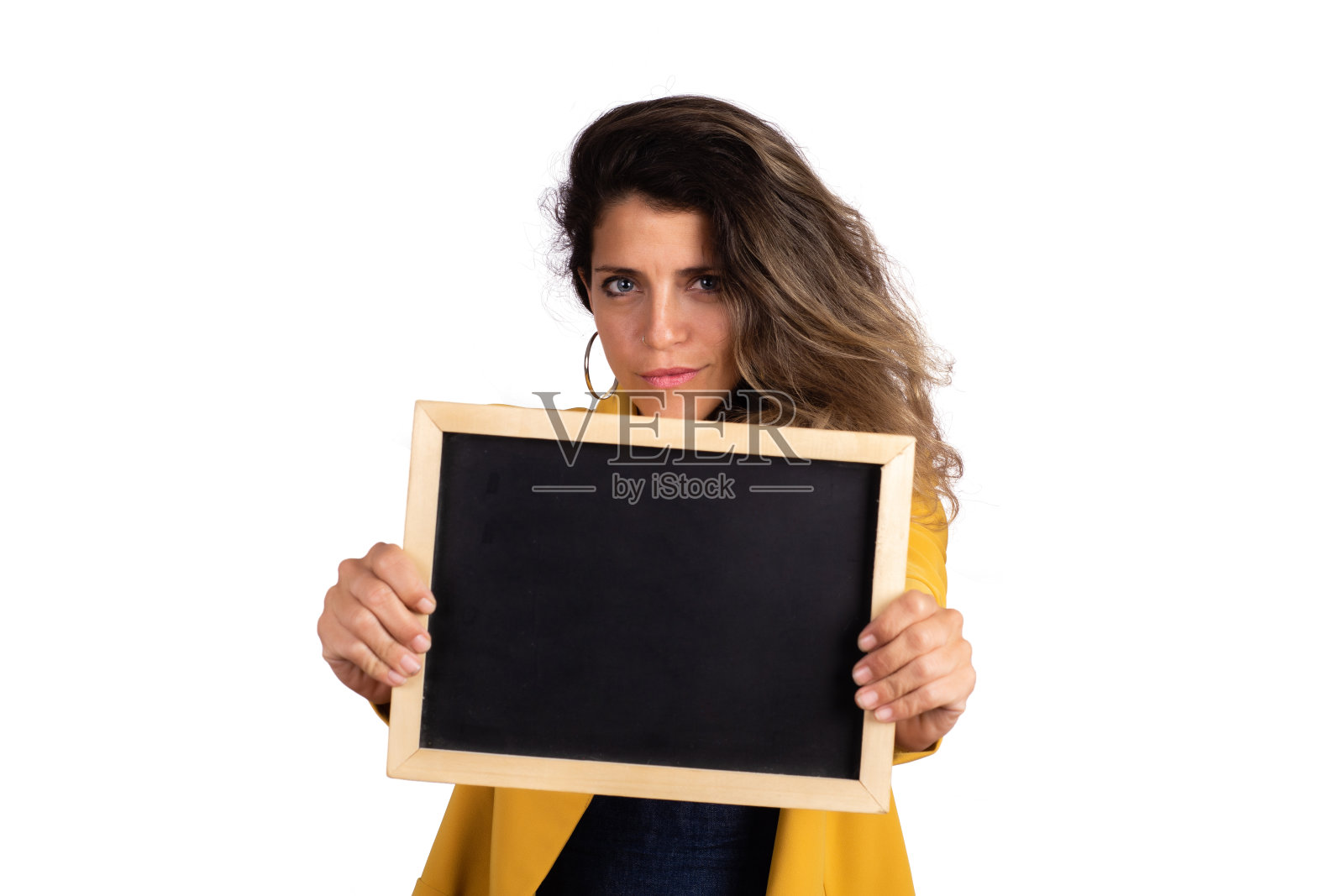 一个女人在工作室里拿着空黑板。照片摄影图片