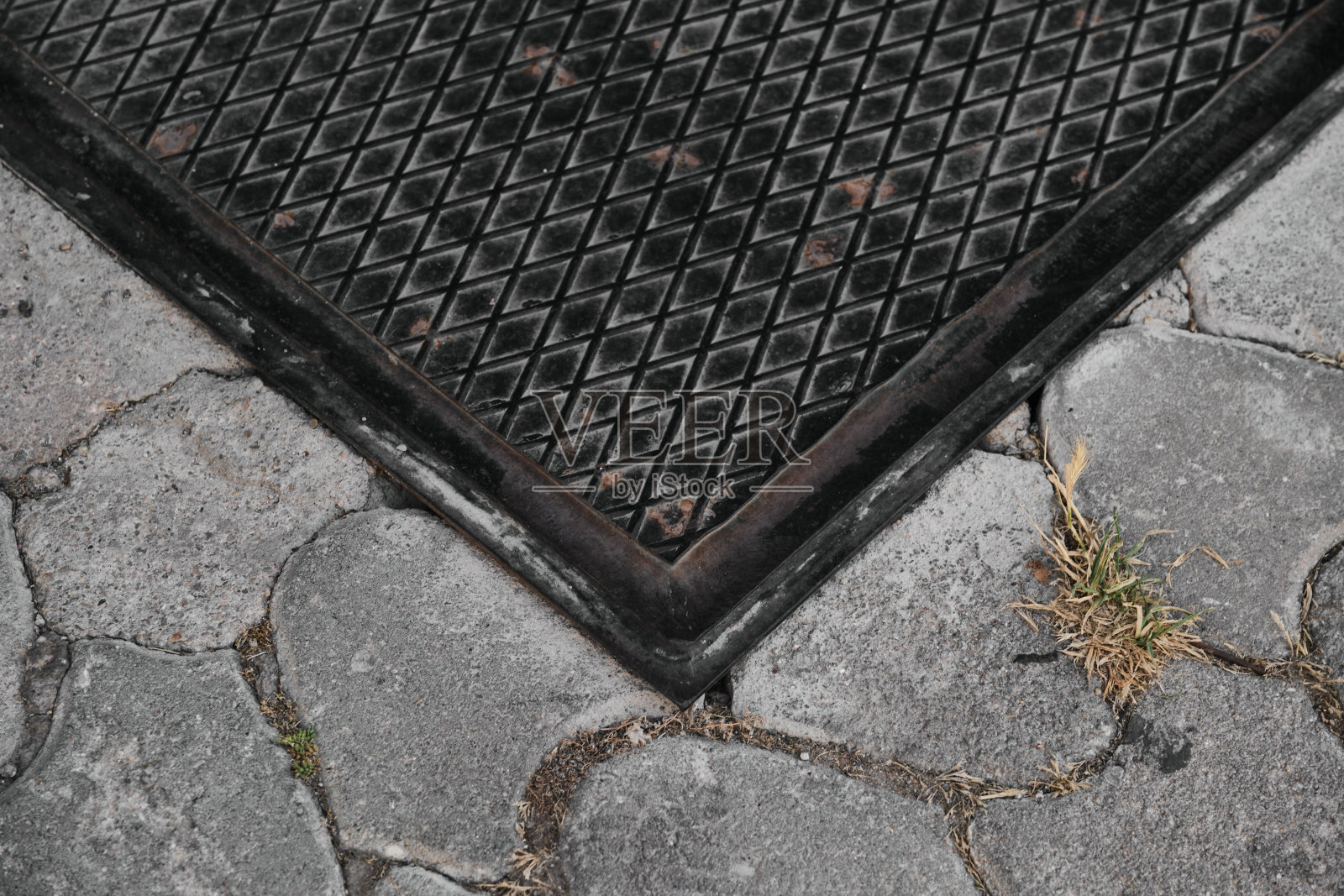 矩形黑色井盖和铺面石细节照片摄影图片