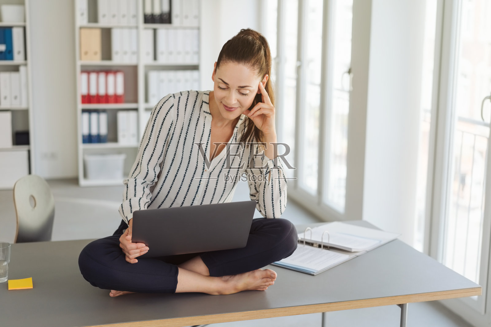 赤脚的年轻女子在用笔记本电脑照片摄影图片