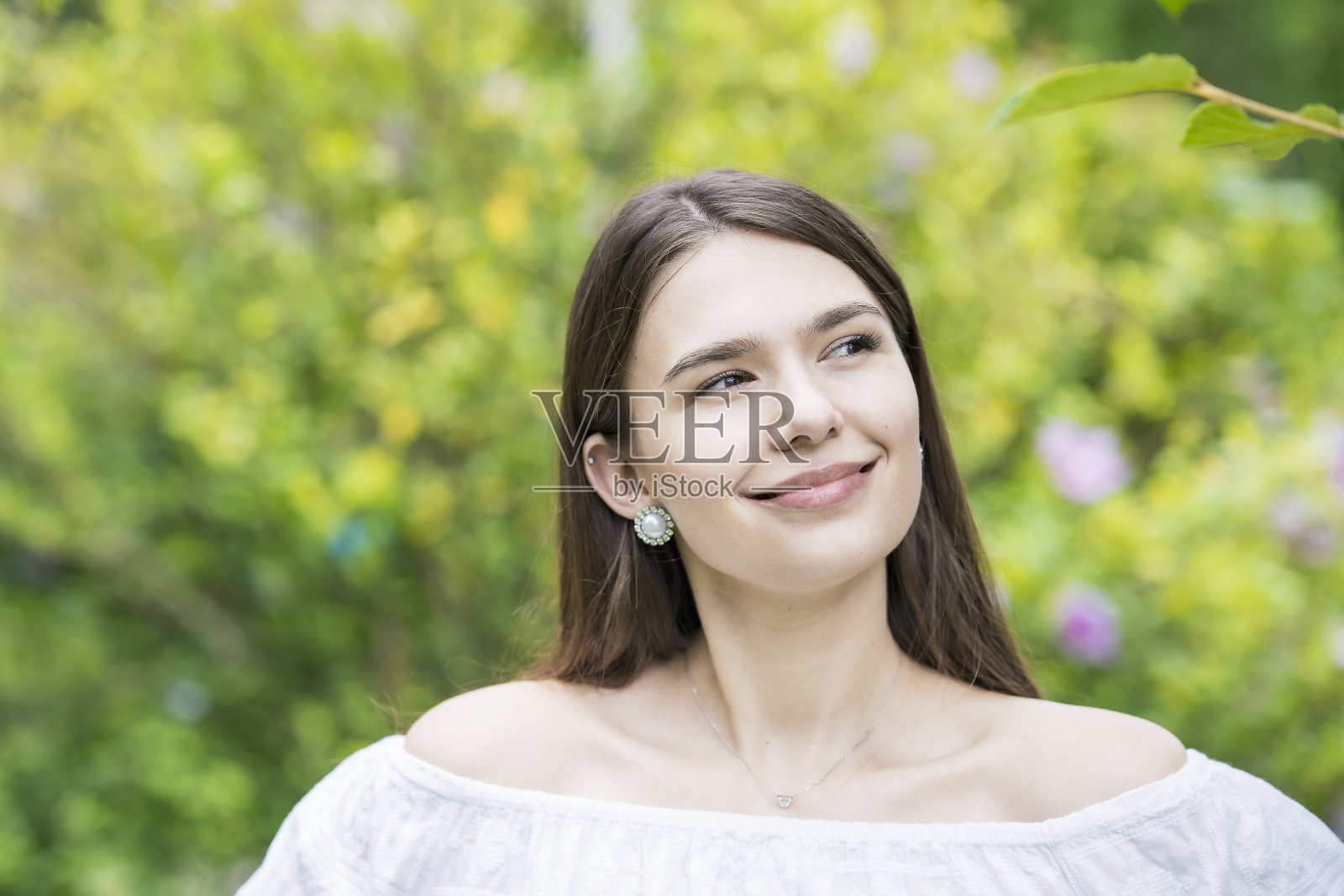 一个穿着白色露肩衬衫的年轻女子照片摄影图片