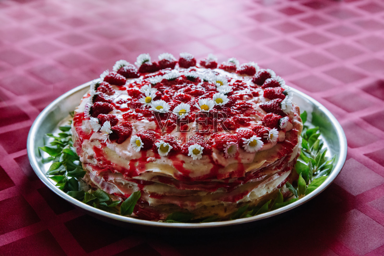 自制蛋糕，用覆盆子、花和绿叶装饰。照片摄影图片