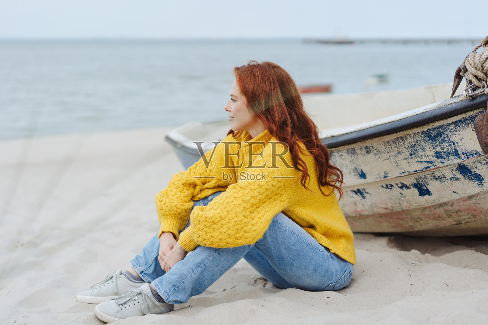 随意的年轻女子享受雾蒙蒙的秋天海滩照片摄影图片