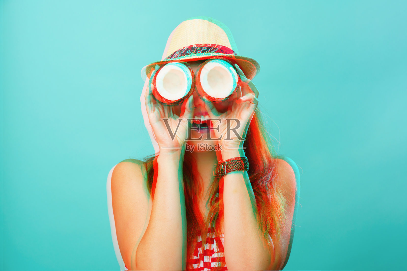 一个女人把两片椰子放在眼睛附近。带有小故障效果的图像照片摄影图片