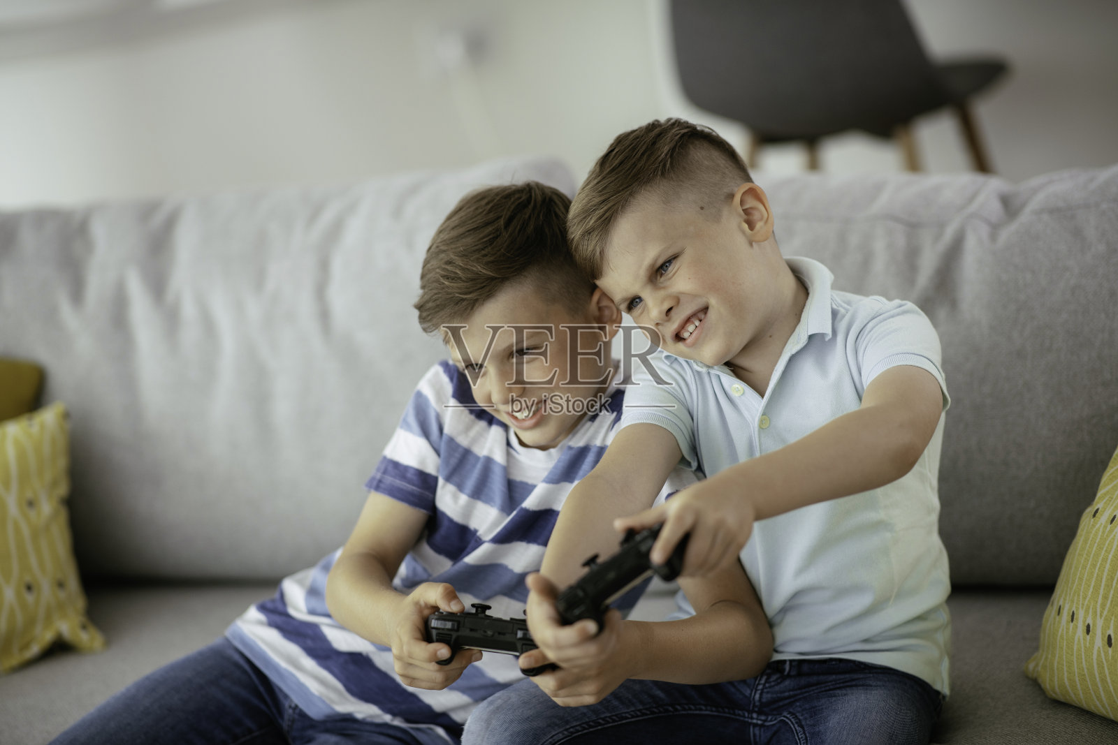 小弟弟们在客厅玩电子游戏时玩得很开心照片摄影图片