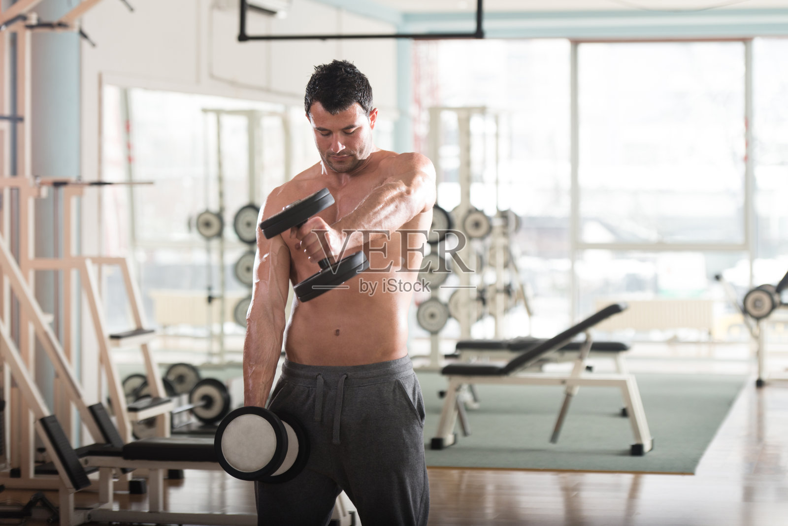 运动员用哑铃锻炼肩膀照片摄影图片