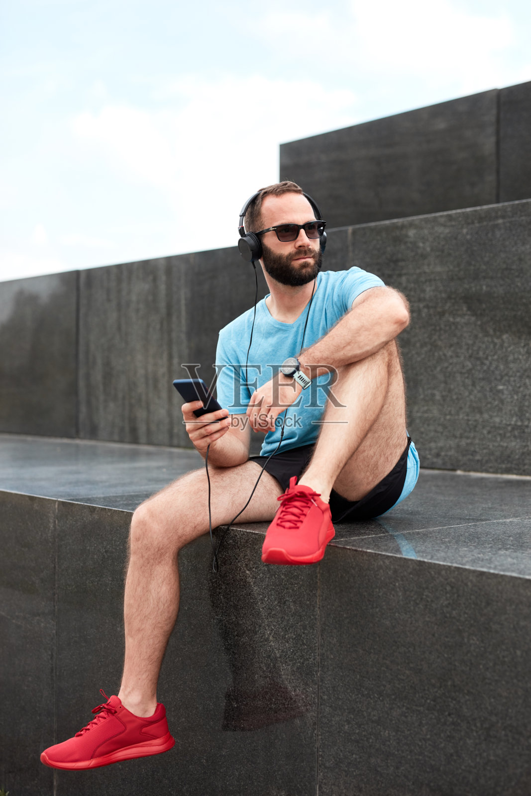 现代运动员在城市环境中慢跑/锻炼后停下来伸展身体。照片摄影图片