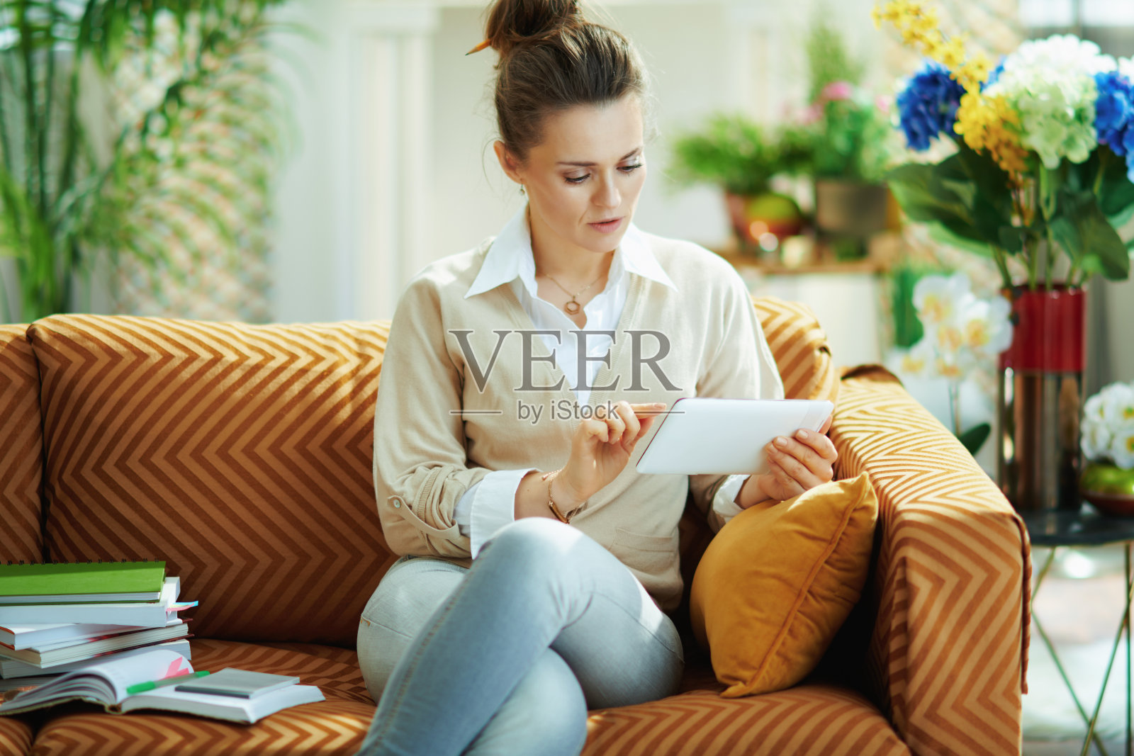 在阳光明媚的日子里，优雅的女人在现代的房子里使用网络学校照片摄影图片