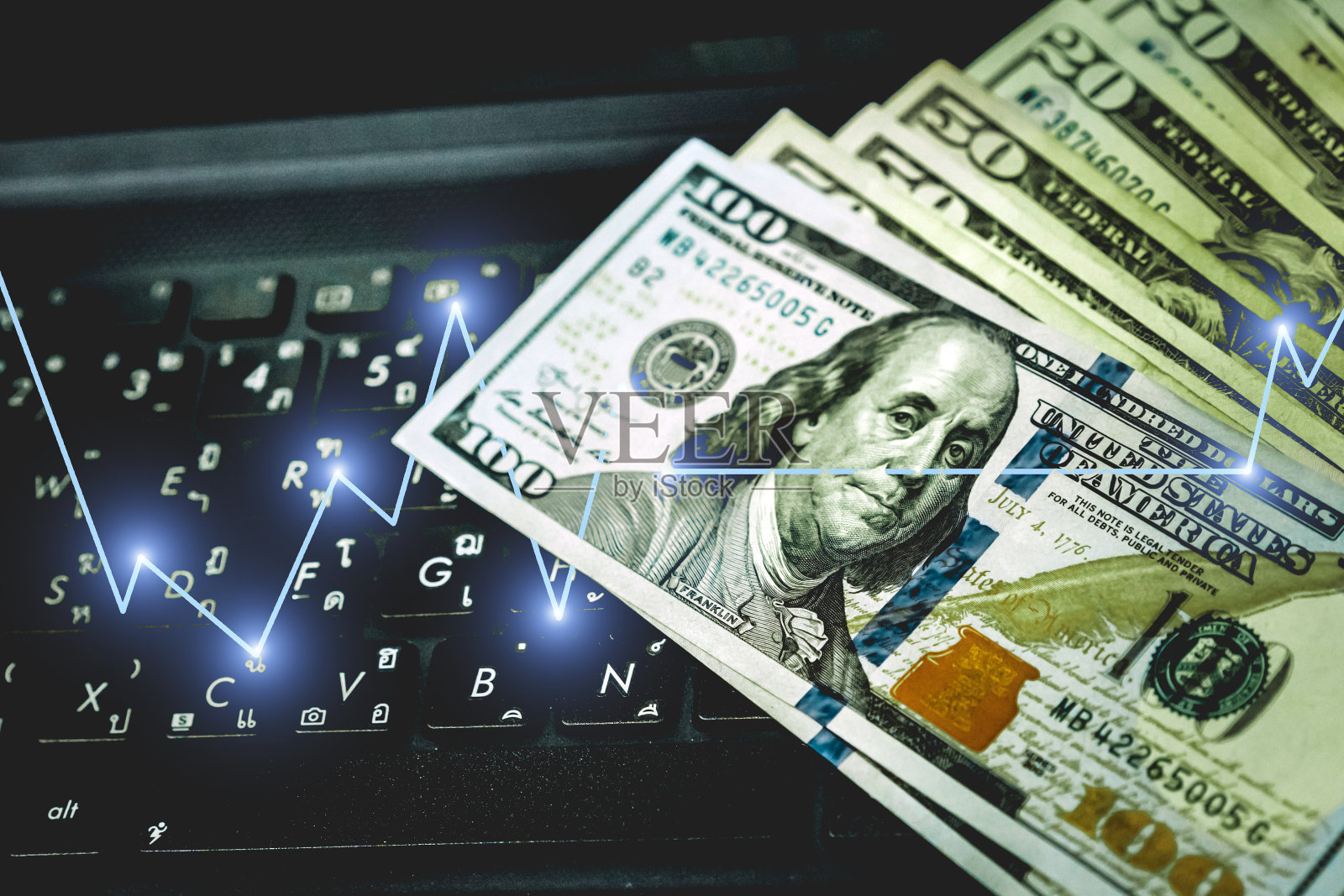 美元货币，美元现金货币与键盘电脑，商业成功概念与股票市场或外汇交易图形。照片摄影图片