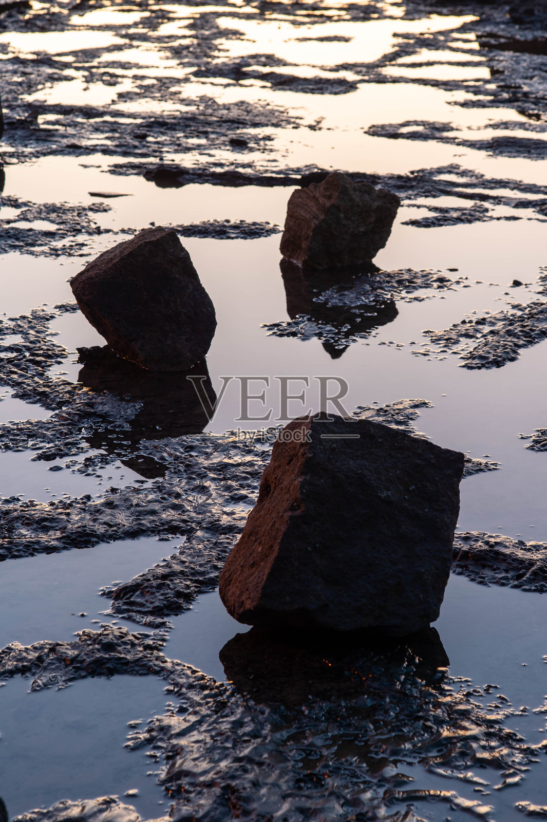 黎明时分躺在岸边的一块岩石照片摄影图片