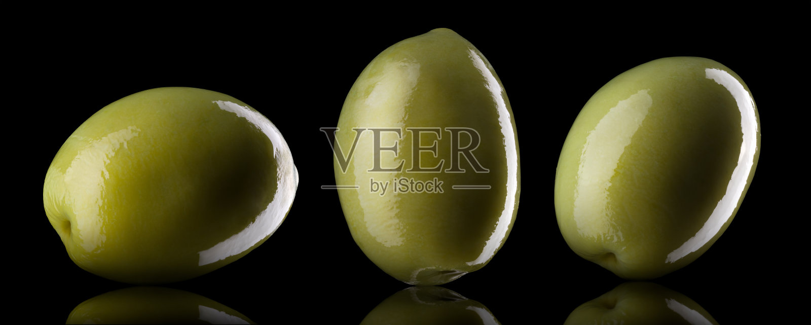 一组光反射孤立在黑色上的绿色橄榄照片摄影图片