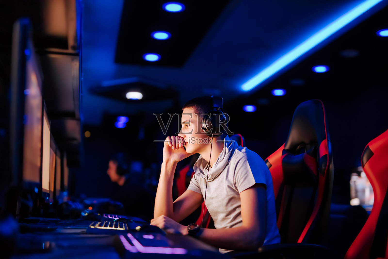 一个沉思的职业玩家在网吧的肖像，侧视图。照片摄影图片