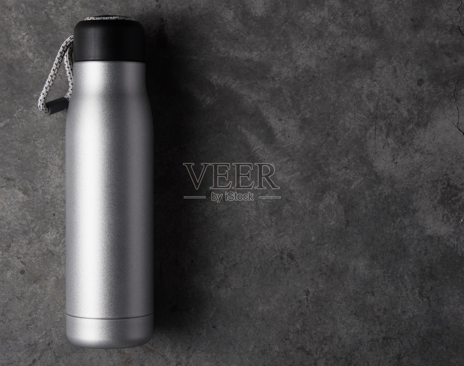 混凝土背景上的可重复使用的水瓶照片摄影图片