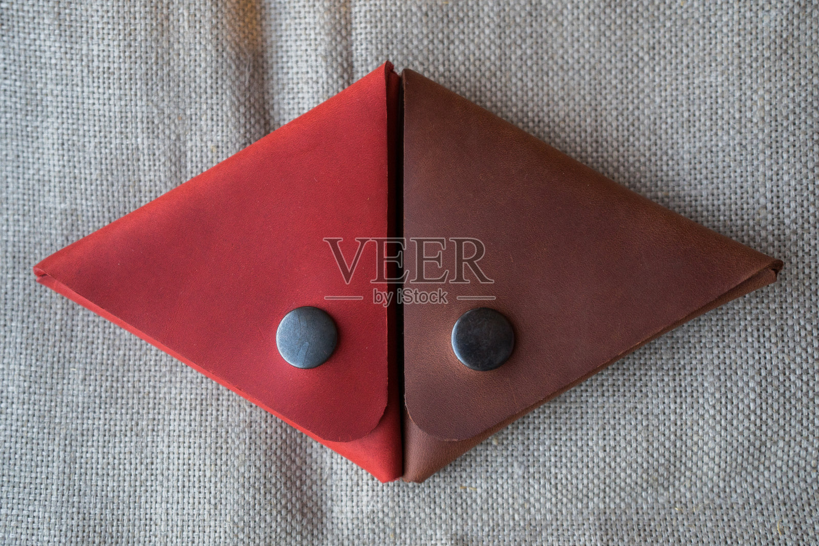 手工制作的红色和棕色的皮革钱包硬币。皮革三角投币箱照片摄影图片