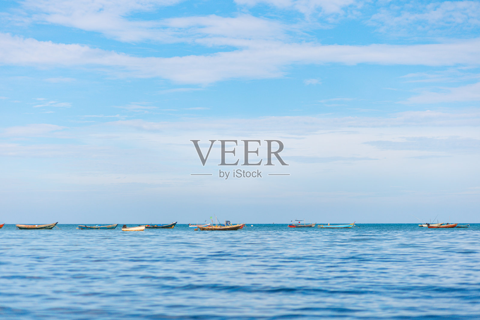 蓝海蓝天上的渔船。照片摄影图片