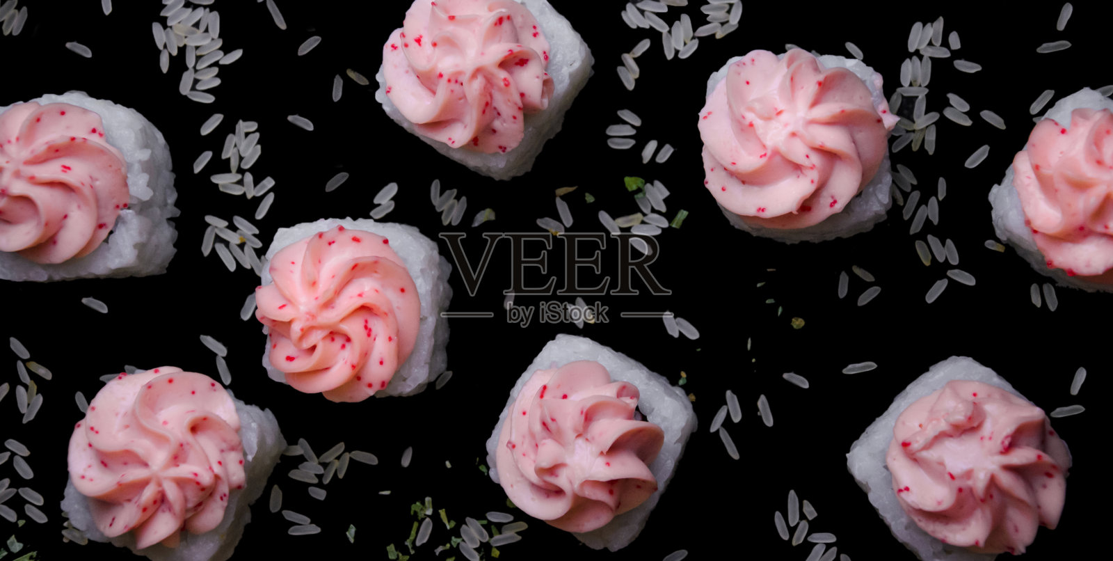 在黑色的特写背景上，白色的寿司熔岩和米饭一起飞了起来照片摄影图片