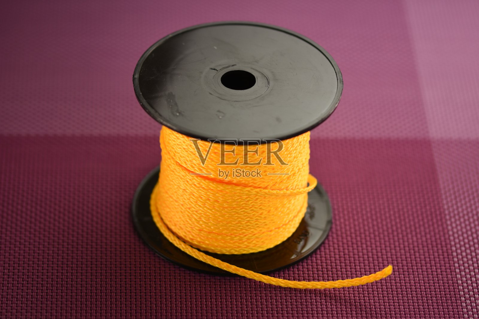 黄色合成绳线圈隔离在黑色背景上。照片摄影图片