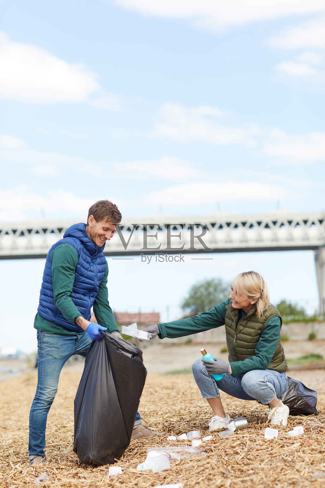 一对年轻夫妇正在清理河岸照片摄影图片