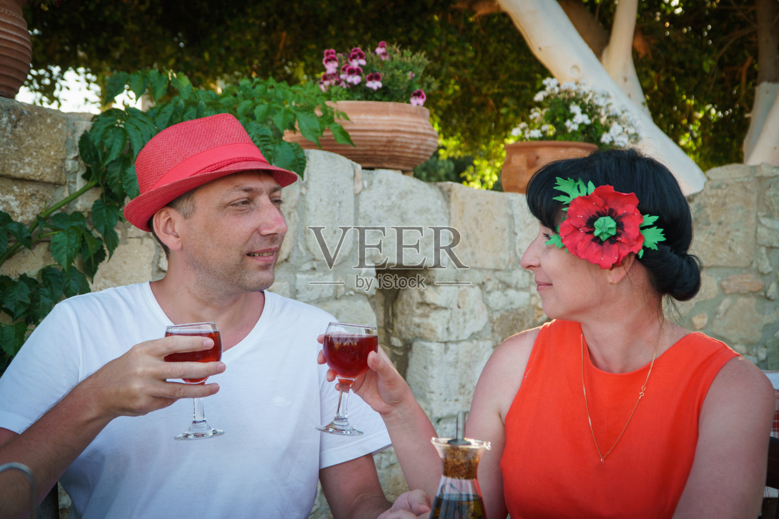 一对成年夫妇在餐馆里吃晚饭、喝葡萄酒。希腊。照片摄影图片