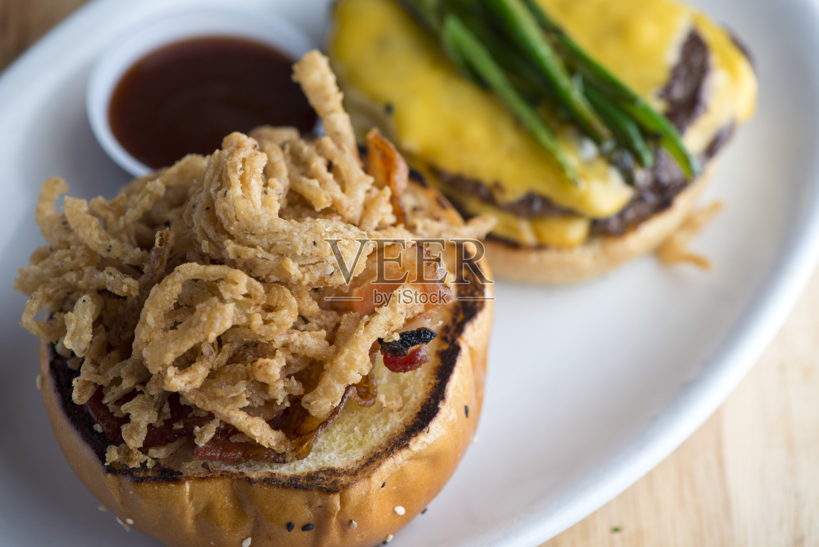 培根芝士汉堡。经典美式汉堡配牛肉饼、香脆培根、融化的瑞士和切达奶酪、焦糖洋葱、生菜、西红柿，配上烤好的奶油面包和酥脆的薯条。美国酒吧食物的最爱。照片摄影图片