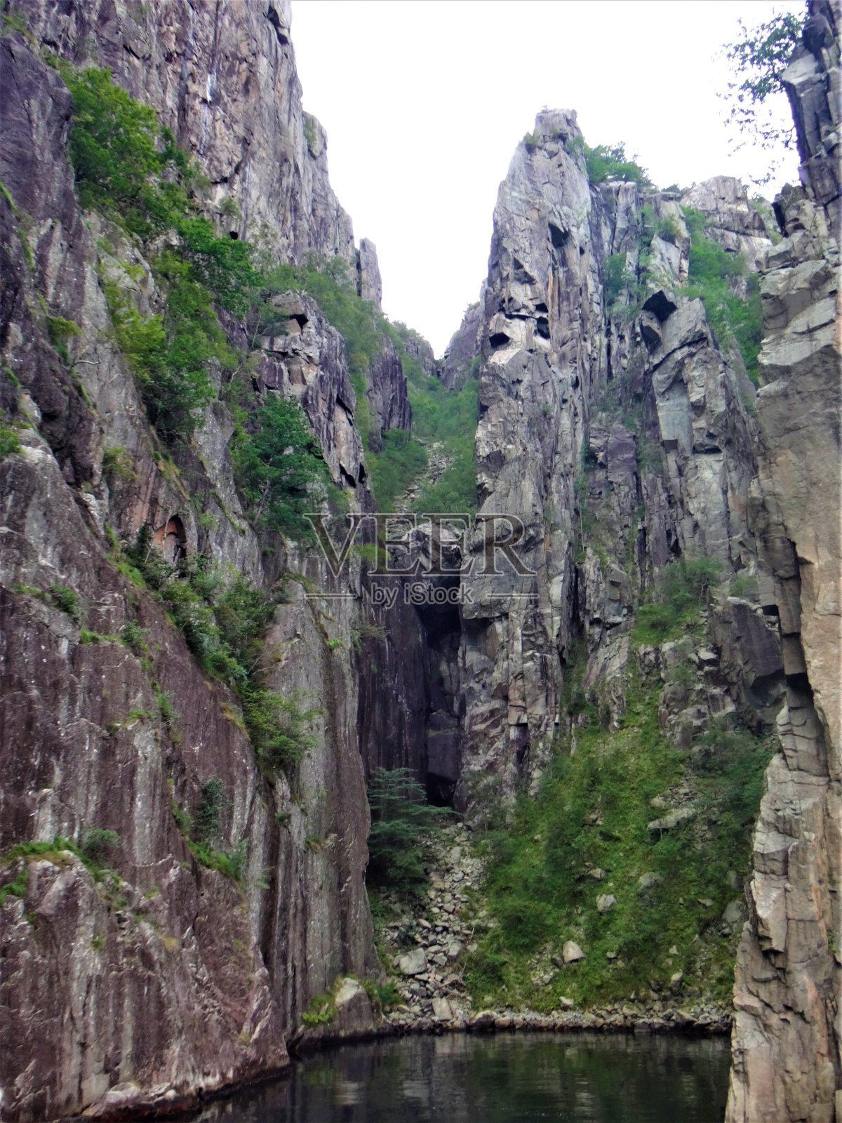 挪威多云的灰色天空下的悬崖、峡湾和山脉照片摄影图片