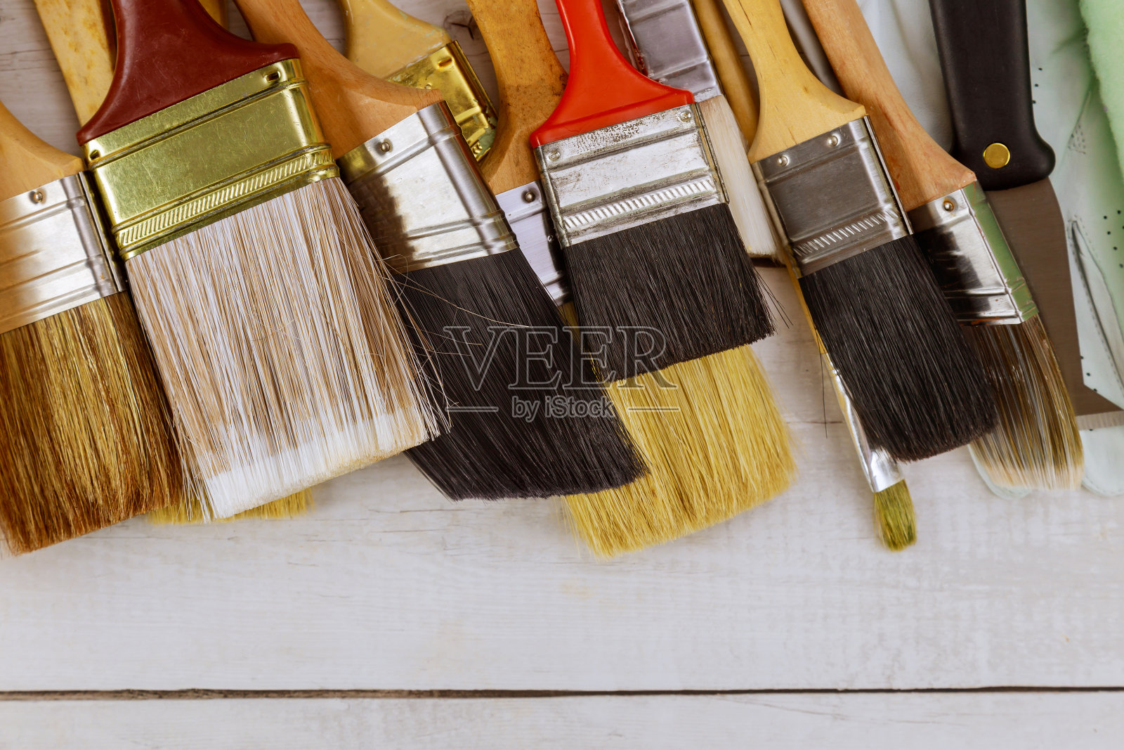 各种油漆工具刷在白色木制桌子的背景上照片摄影图片