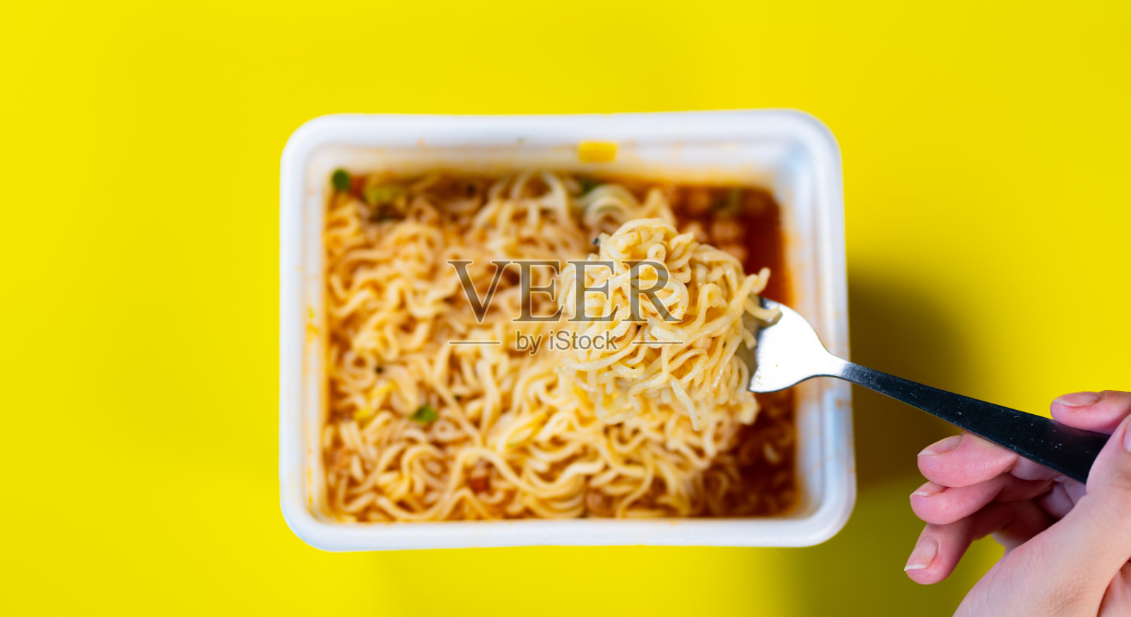 特写的现成方便面与香料和叉子在黄色的背景照片摄影图片